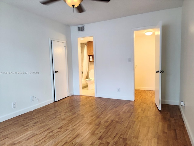 unfurnished bedroom with wood-type flooring, connected bathroom, and ceiling fan