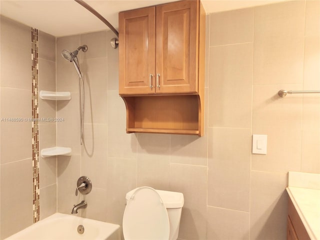 full bathroom with vanity, toilet, tile walls, and tiled shower / bath combo