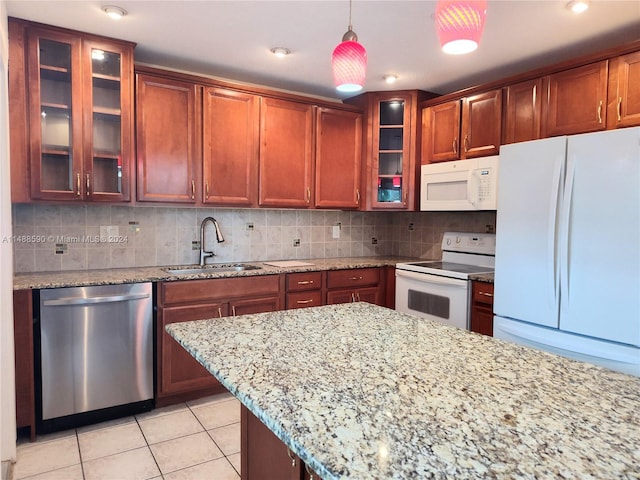 kitchen with white appliances, backsplash, hanging light fixtures, and sink