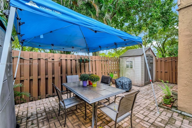 view of patio / terrace with a grill and a storage shed