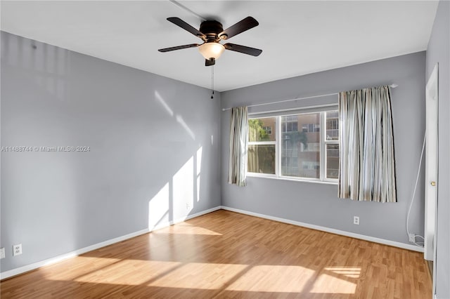 empty room with ceiling fan and light hardwood / wood-style flooring