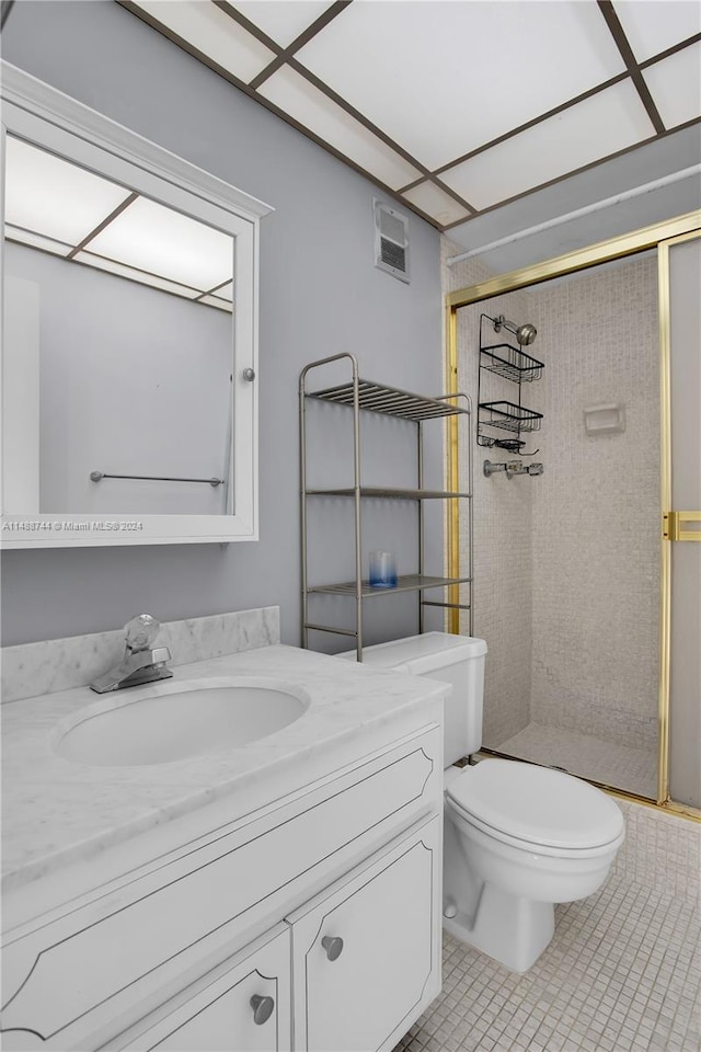 bathroom featuring tile flooring, a shower with shower door, oversized vanity, and toilet