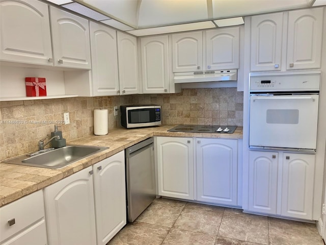 kitchen featuring sink, backsplash, light tile flooring, and stainless steel appliances