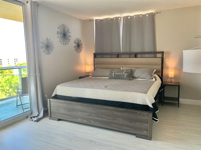 bedroom featuring a textured ceiling, access to exterior, and light wood-type flooring