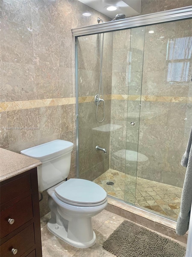 bathroom featuring tile walls, toilet, an enclosed shower, tile floors, and vanity