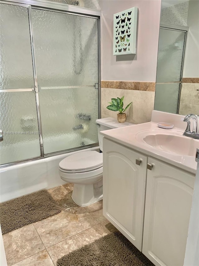 full bathroom with vanity, tile floors, toilet, and tile walls