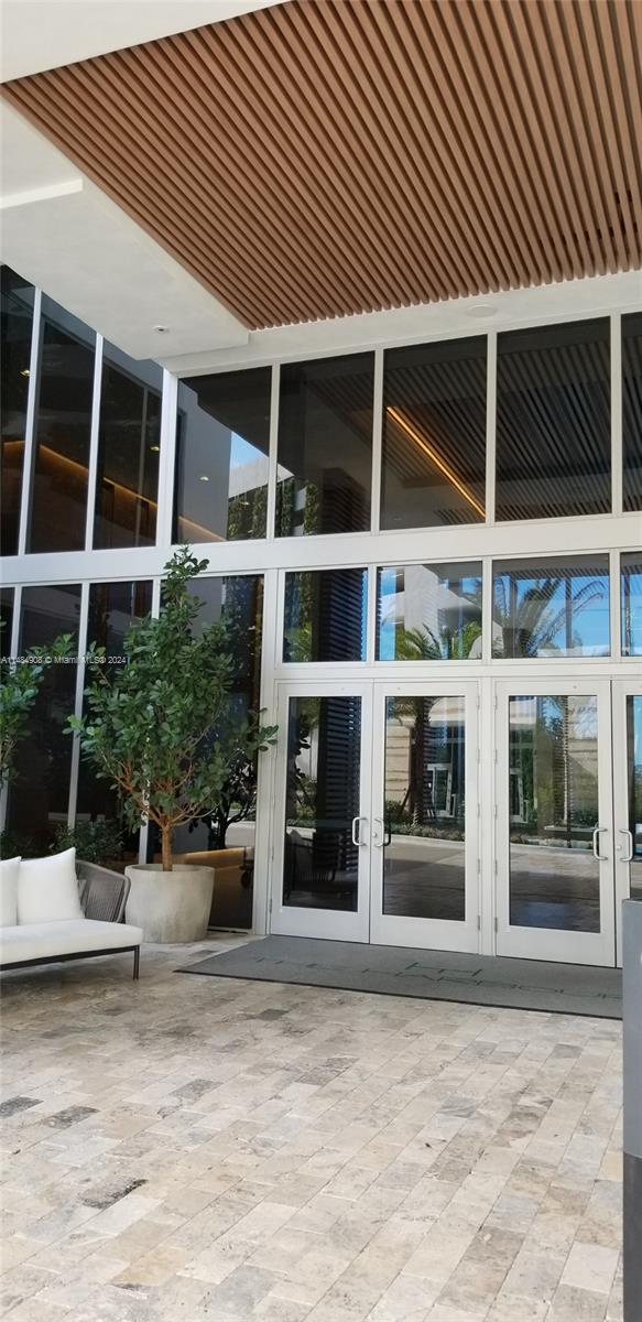 property entrance featuring a patio and french doors