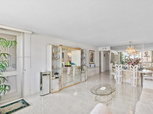 tiled living room featuring a chandelier, wine cooler, and a textured ceiling