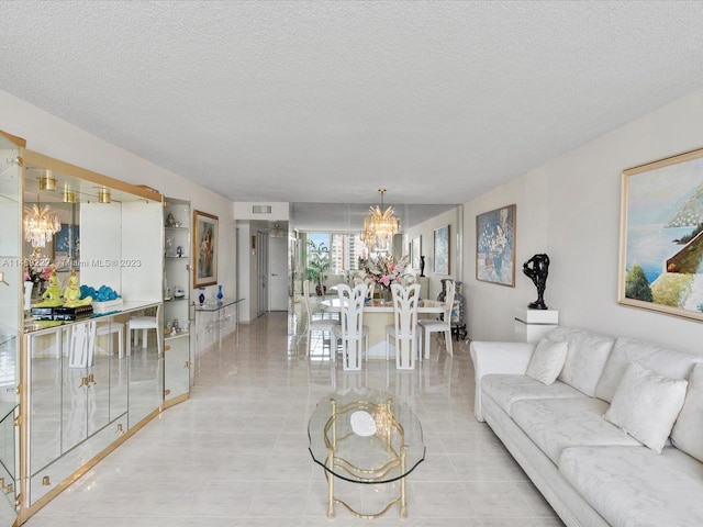 living room with a textured ceiling, a notable chandelier, and light tile floors