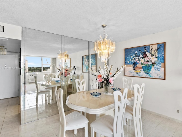 dining space with light tile floors, a textured ceiling, and an inviting chandelier