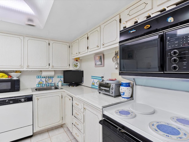 kitchen with light tile flooring, white dishwasher, white cabinets, and sink