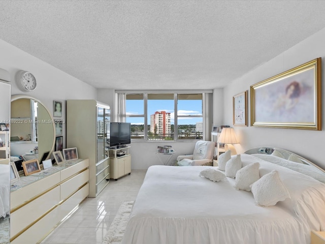 bedroom with light tile floors and a textured ceiling