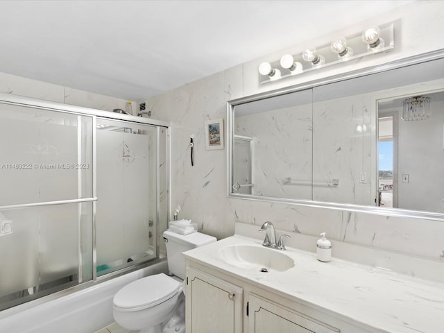 full bathroom featuring tile walls, enclosed tub / shower combo, toilet, and vanity