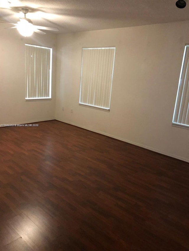 spare room with ceiling fan and dark hardwood / wood-style flooring