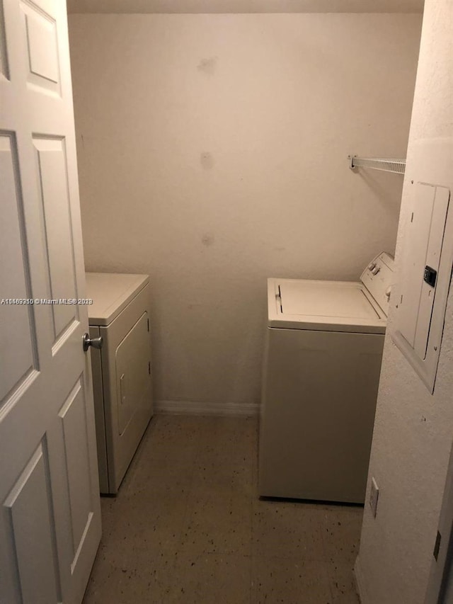 laundry room featuring light tile floors and washer and clothes dryer