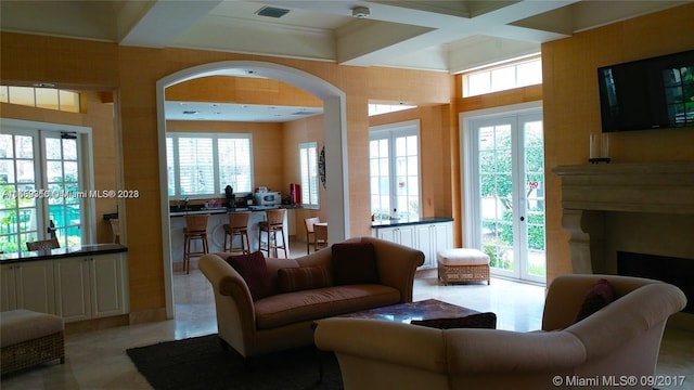 tiled living room featuring coffered ceiling and french doors