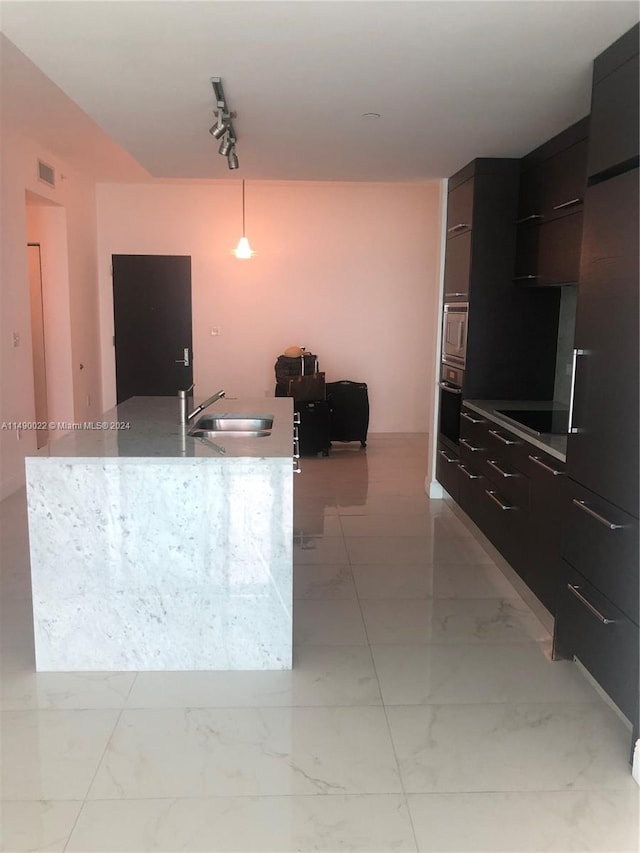 kitchen featuring light tile floors, sink, black electric stovetop, hanging light fixtures, and track lighting