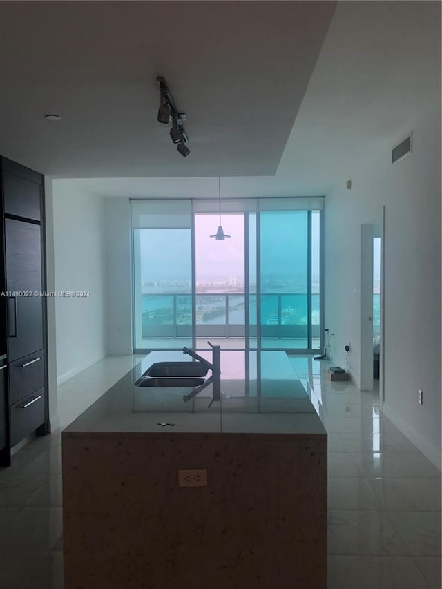 kitchen with sink, tile floors, and a healthy amount of sunlight