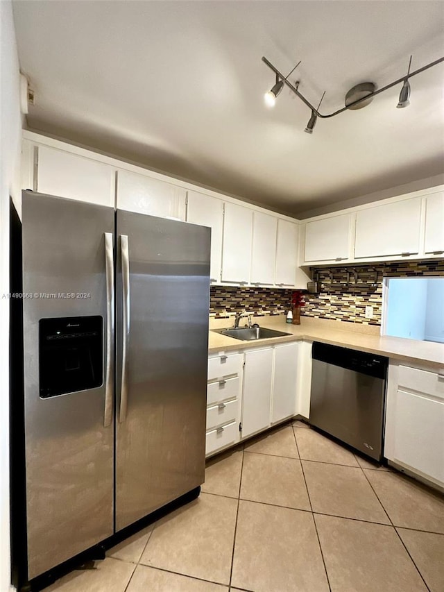 kitchen with appliances with stainless steel finishes, track lighting, white cabinetry, and sink