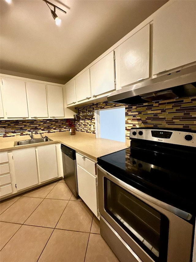 kitchen featuring light tile patterned flooring, stainless steel appliances, white cabinetry, and sink