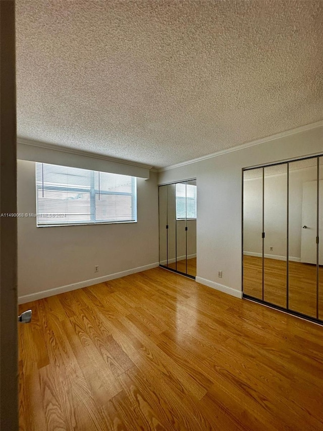 unfurnished bedroom with light wood-type flooring, crown molding, and a textured ceiling