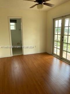 empty room featuring french doors, ceiling fan, and hardwood / wood-style floors