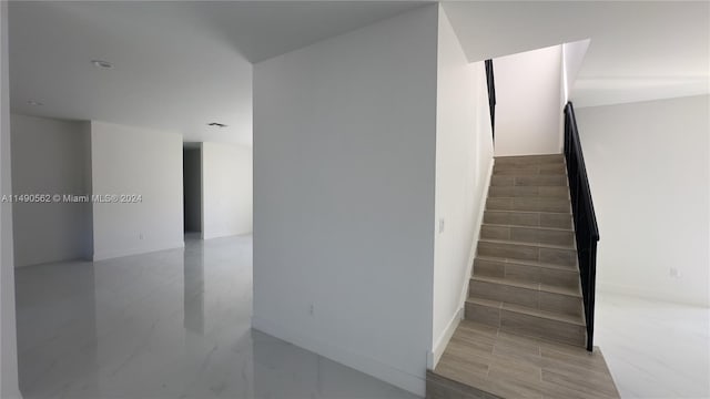 stairway featuring light tile floors