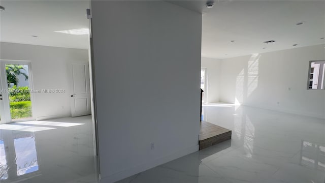 unfurnished room featuring a healthy amount of sunlight and light tile floors