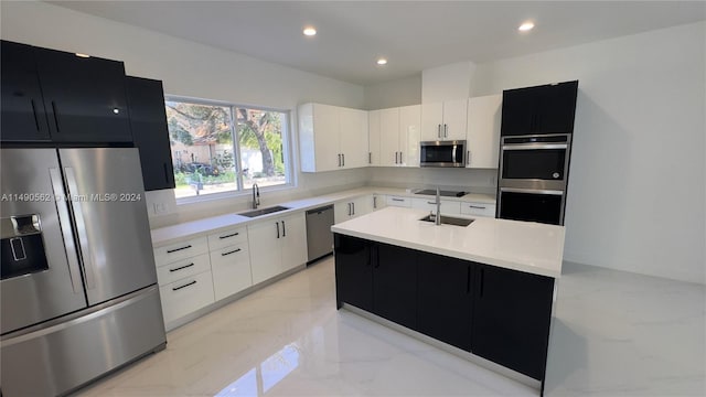 kitchen featuring light tile floors, stainless steel appliances, sink, and a kitchen island with sink