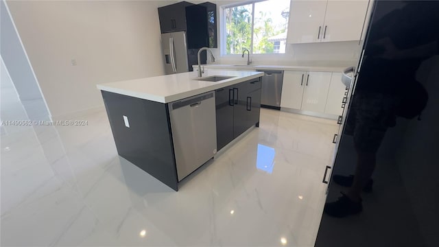 kitchen featuring sink, an island with sink, light tile floors, white cabinets, and stainless steel appliances