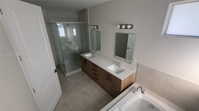 bathroom with independent shower and bath, large vanity, tile flooring, and dual sinks