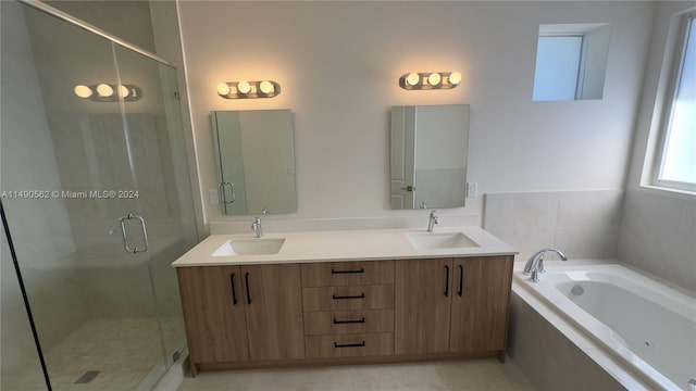 bathroom featuring independent shower and bath, dual vanity, and tile flooring