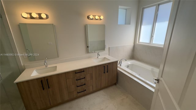 bathroom with tile floors, double vanity, and tiled tub