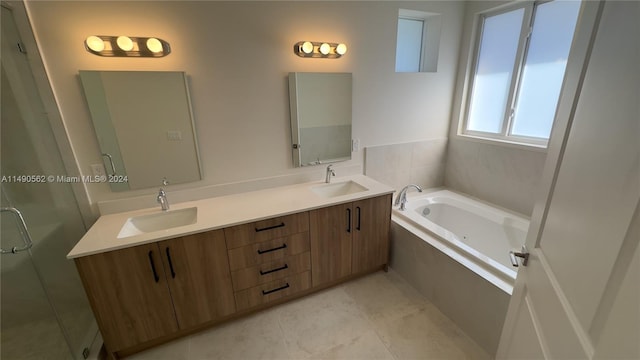 bathroom with a relaxing tiled bath, double sink vanity, and tile floors