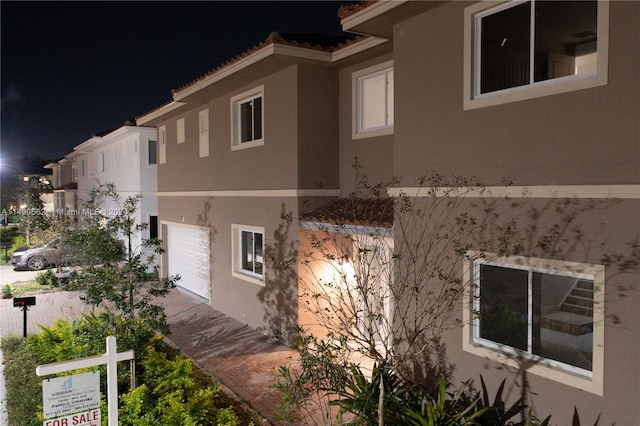 property exterior at twilight featuring a garage