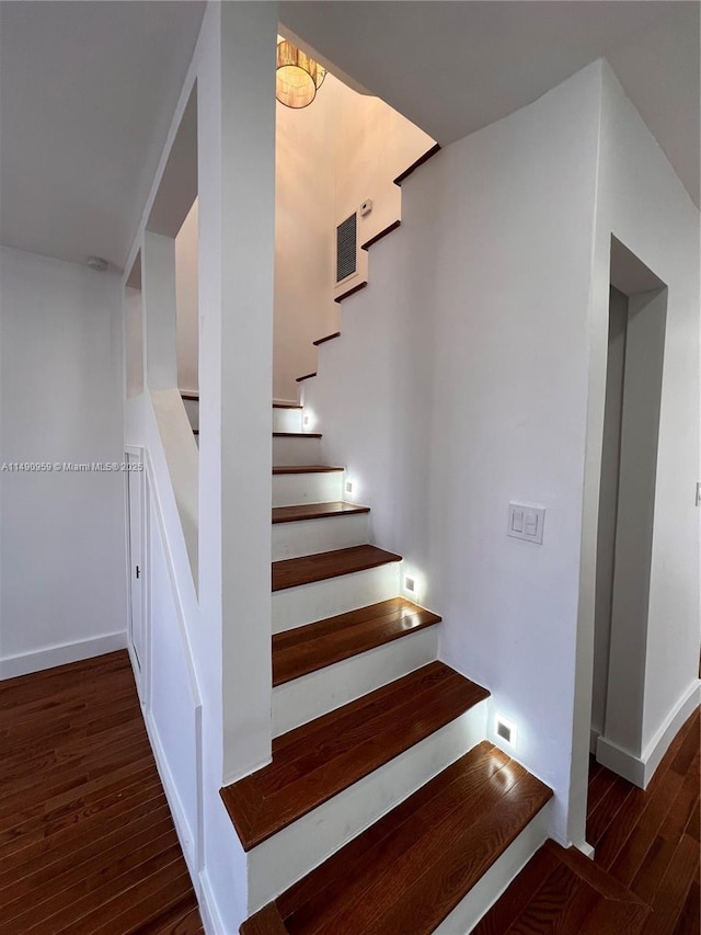 stairway with baseboards and wood finished floors