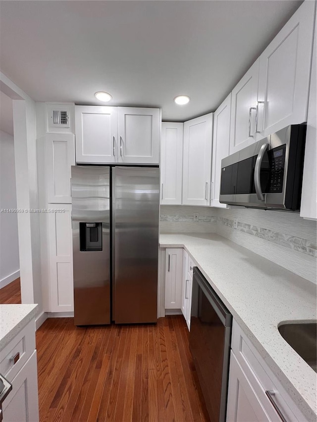 kitchen featuring appliances with stainless steel finishes, visible vents, and white cabinetry