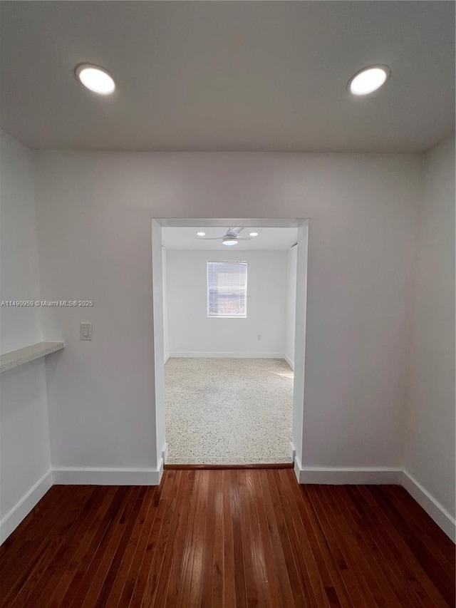 empty room featuring dark wood-type flooring, recessed lighting, and baseboards