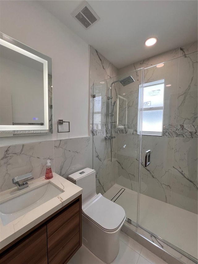 bathroom with toilet, vanity, visible vents, tile walls, and a marble finish shower