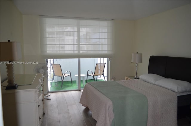 bedroom featuring light hardwood / wood-style floors, access to exterior, and multiple windows