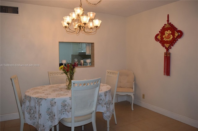 tiled dining area featuring an inviting chandelier