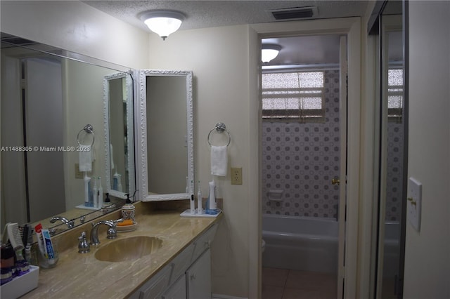 bathroom featuring tile floors, a textured ceiling, shower / bathing tub combination, and vanity