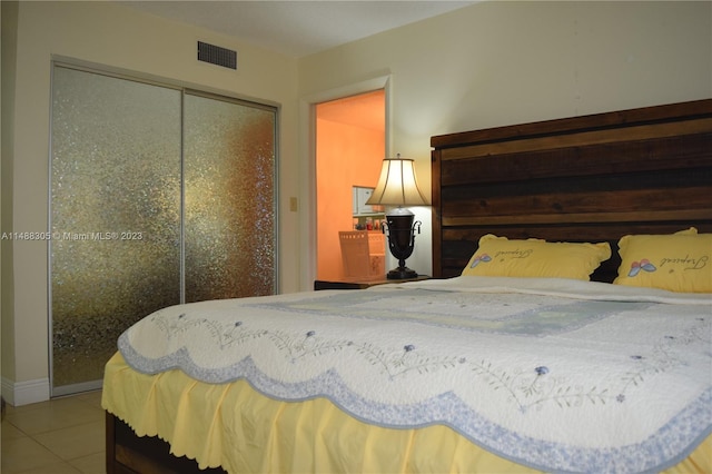 bedroom with a closet and light tile floors