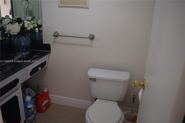 bathroom with tile flooring, vanity with extensive cabinet space, and toilet