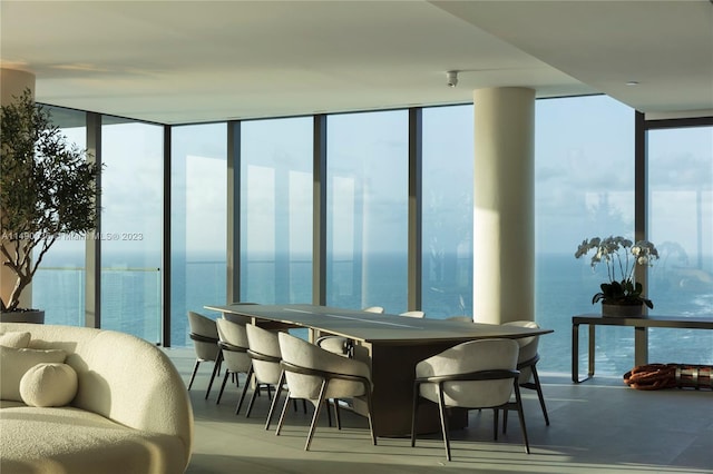 dining space featuring floor to ceiling windows and a water view