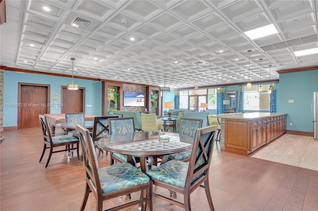 dining area featuring light wood-type flooring and crown molding