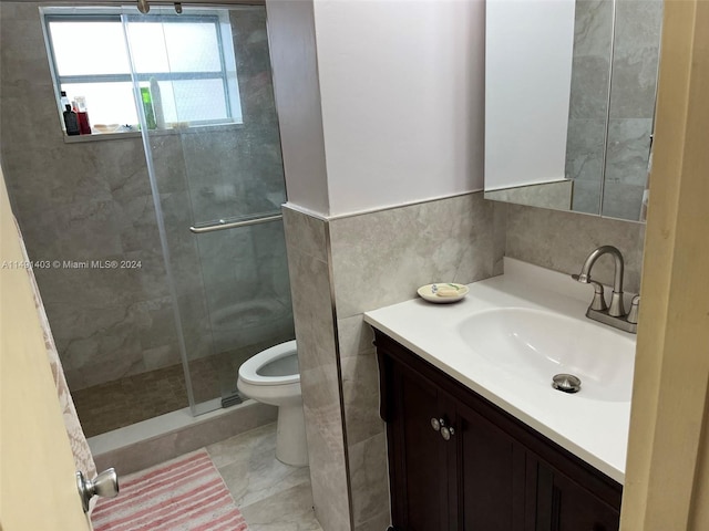 bathroom featuring tile walls, vanity, toilet, and an enclosed shower