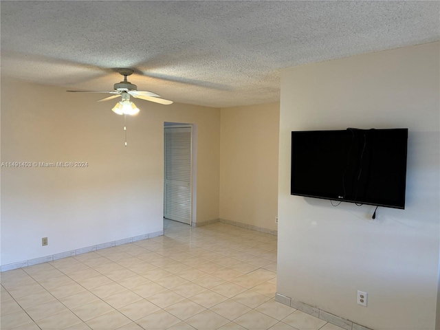 tiled spare room featuring ceiling fan and a textured ceiling