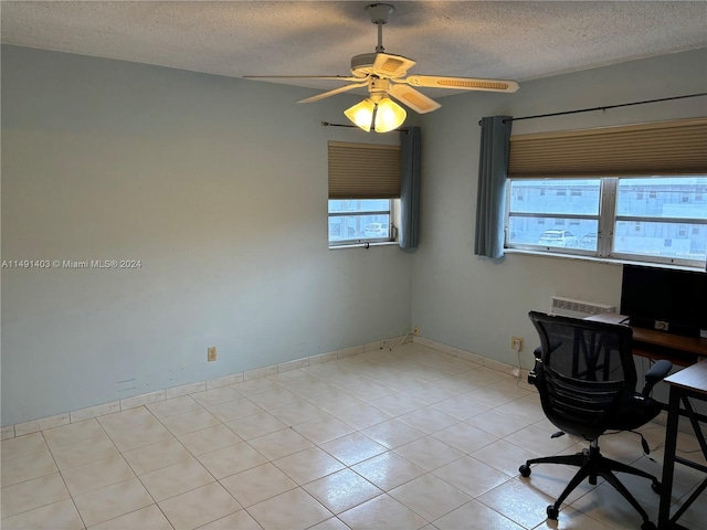 unfurnished office with a textured ceiling, light tile patterned floors, and ceiling fan