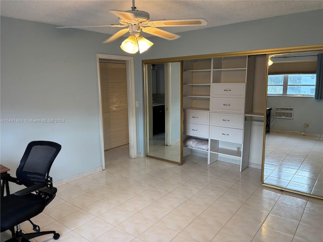 tiled office with a wall unit AC, a textured ceiling, and ceiling fan